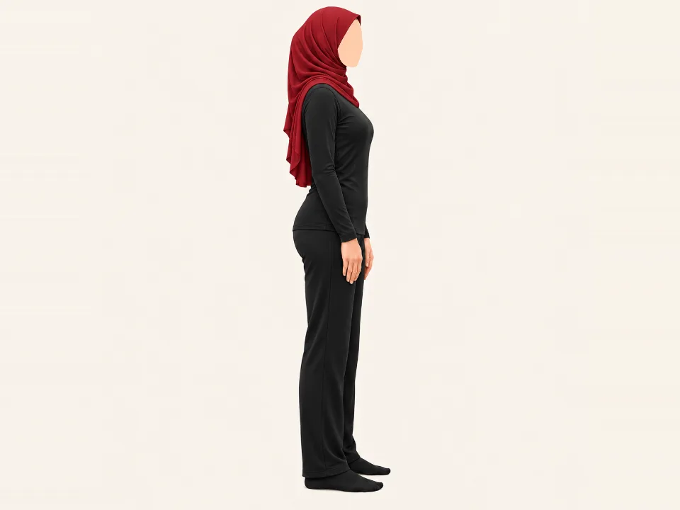 Woman in a red hijab standing with her hands on her thighs, hinging at the hips with a long back.