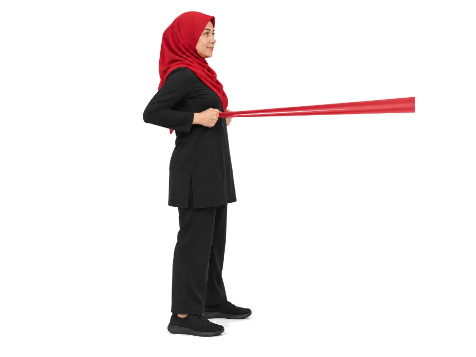 Illustrative image, not a real patient. A woman in a red hijab stands tall pulling a red resistance band toward her, elbows drawn back.
