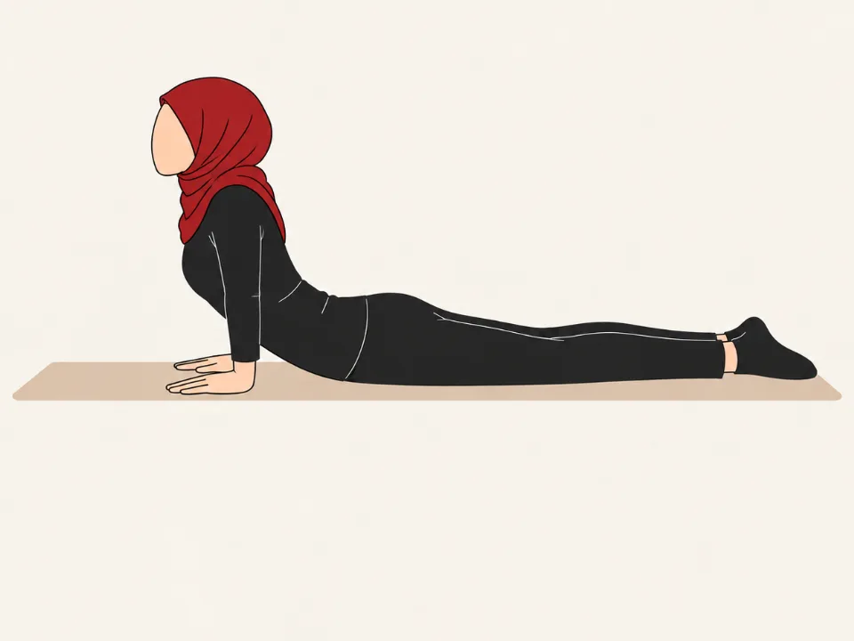 Woman in a red hijab lying face down, pushing her upper body up on her hands with her hips on the mat.